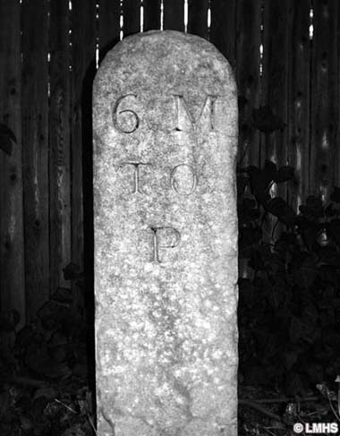 narrow round-top stone carved with 6 M to P