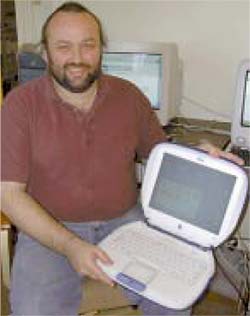seated man holding an open laptop